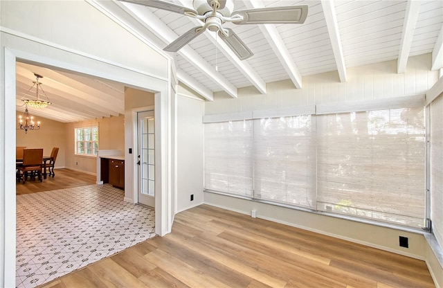 interior space featuring lofted ceiling with beams, ceiling fan with notable chandelier, and light hardwood / wood-style floors