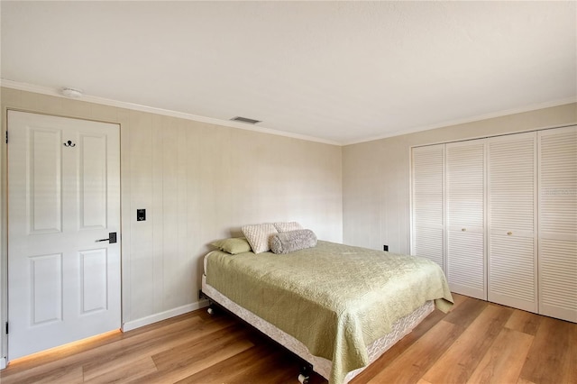 bedroom with crown molding, a closet, and light hardwood / wood-style flooring