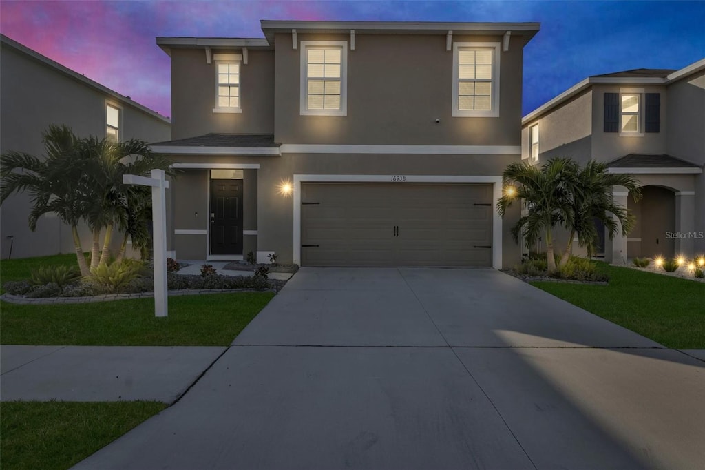 view of front of property featuring a lawn and a garage