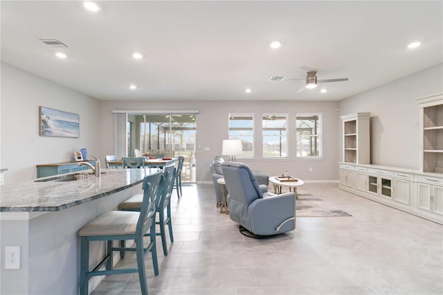 living room with ceiling fan and sink