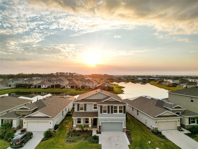 aerial view at dusk featuring a water view