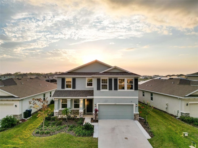 view of front of home featuring covered porch, driveway, a lawn, and an attached garage