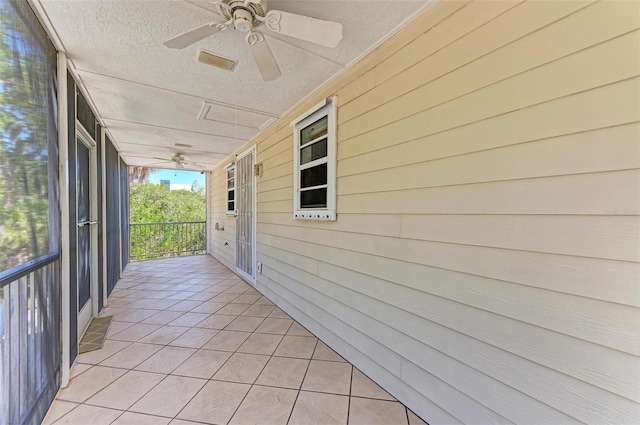 unfurnished sunroom featuring ceiling fan