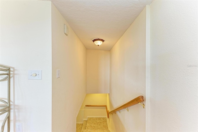 stairs featuring a textured ceiling