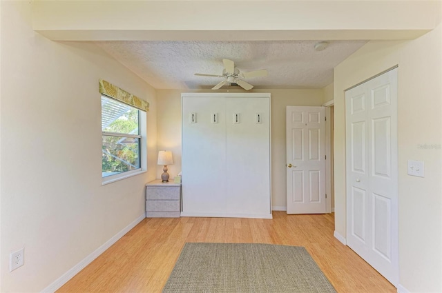 interior space with ceiling fan, light hardwood / wood-style flooring, and a textured ceiling