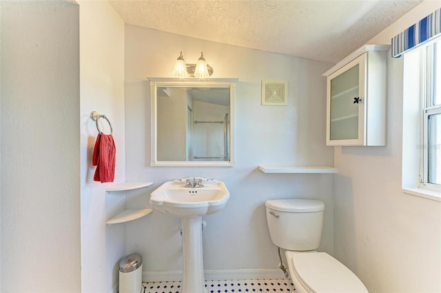 bathroom featuring lofted ceiling, a textured ceiling, and toilet