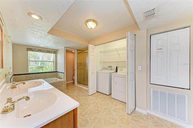 bathroom with vanity, tile patterned flooring, separate washer and dryer, a textured ceiling, and shower with separate bathtub