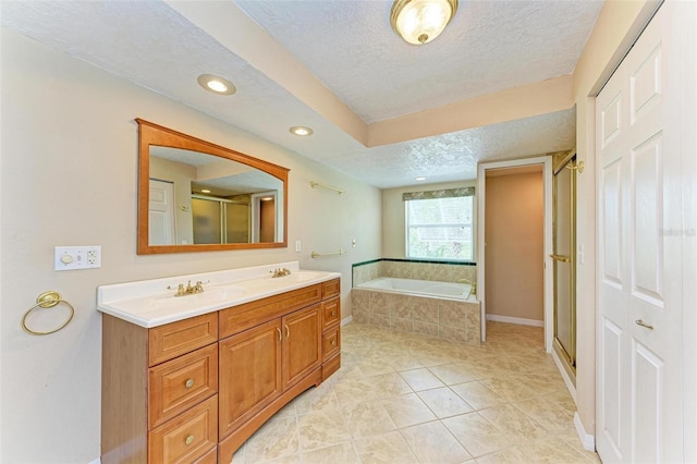 bathroom featuring tile patterned flooring, vanity, independent shower and bath, and a textured ceiling