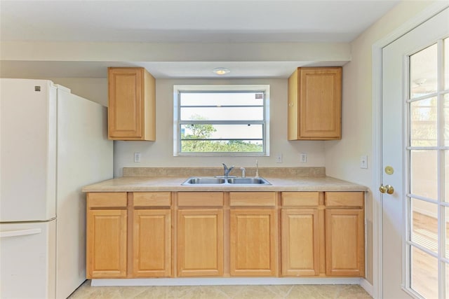 kitchen with sink, light tile patterned floors, and white refrigerator