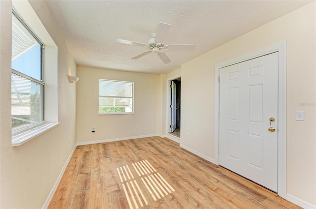 unfurnished bedroom featuring ceiling fan, light wood-type flooring, and a textured ceiling