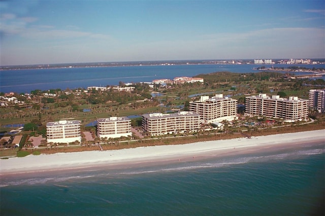 birds eye view of property with a water view and a beach view