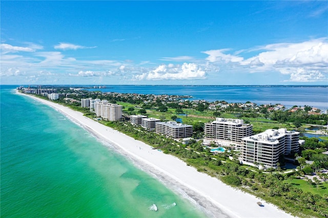 drone / aerial view featuring a city view, a water view, and a beach view