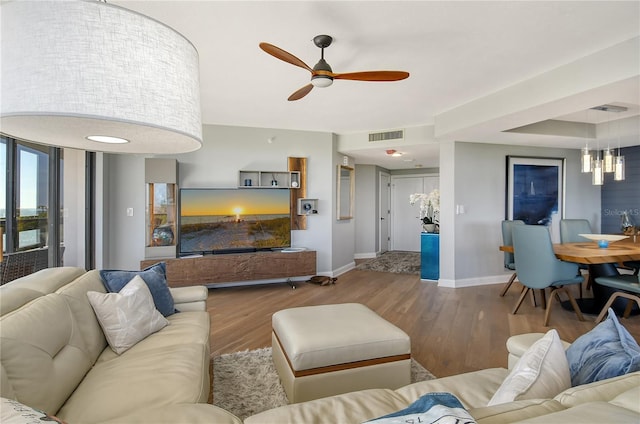 living room featuring hardwood / wood-style floors and ceiling fan