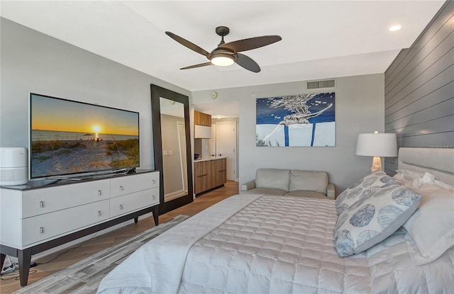 bedroom with ceiling fan, light hardwood / wood-style flooring, and ensuite bath