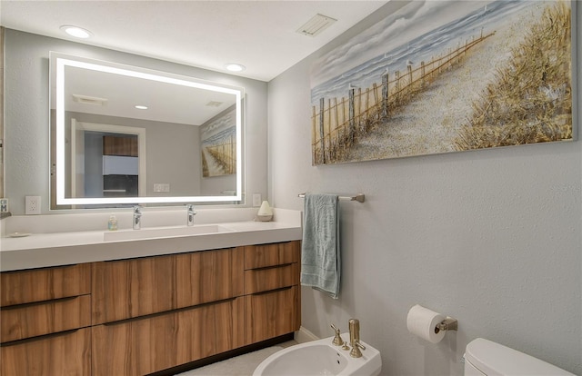 bathroom with vanity, a bidet, and toilet