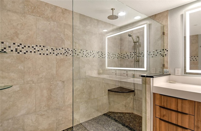 bathroom featuring a tile shower and vanity