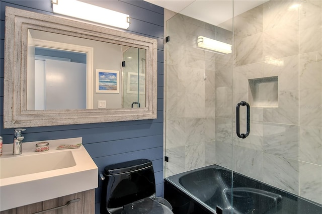 bathroom with wooden walls, vanity, and enclosed tub / shower combo