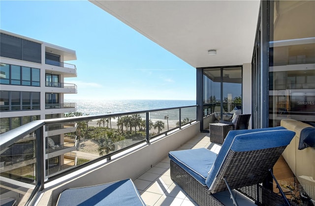 balcony featuring a water view and a beach view