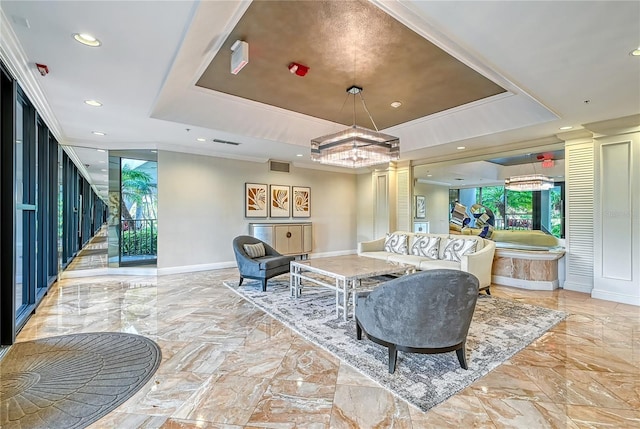 living room featuring decorative columns, a raised ceiling, and crown molding