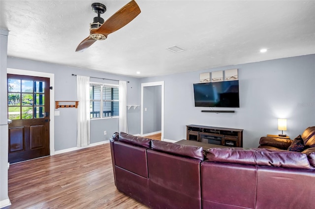 living room featuring ceiling fan and light hardwood / wood-style flooring