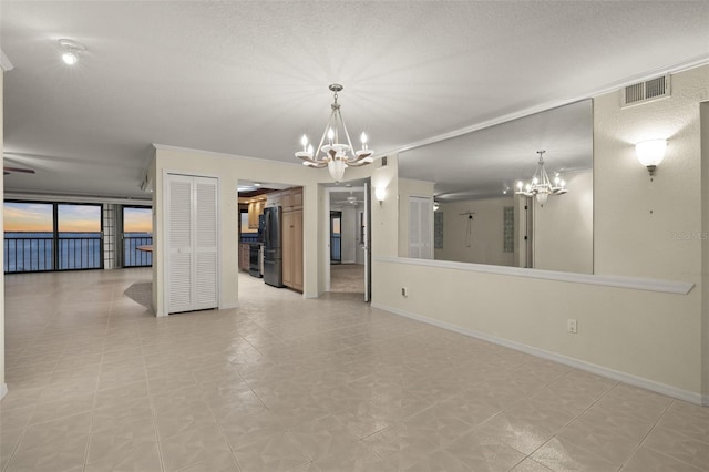 unfurnished room featuring a wall of windows and a chandelier