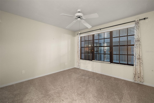 empty room featuring ceiling fan and carpet