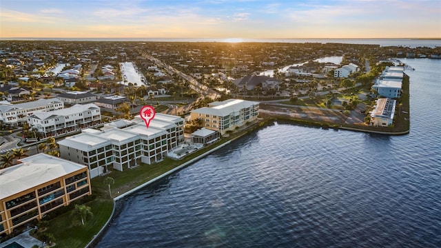 aerial view at dusk featuring a water view