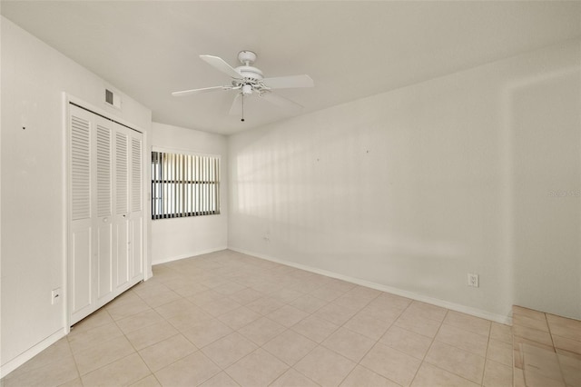 unfurnished bedroom with ceiling fan, light tile patterned floors, and a closet