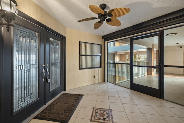 interior space with ceiling fan, french doors, and a textured ceiling