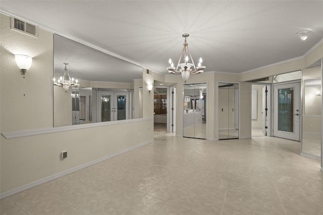 tiled empty room with a textured ceiling, ornamental molding, french doors, and an inviting chandelier