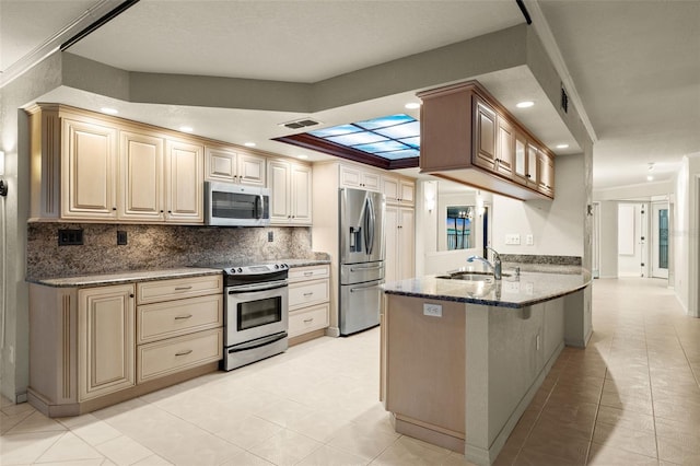 kitchen featuring kitchen peninsula, a kitchen bar, light tile patterned flooring, sink, and appliances with stainless steel finishes