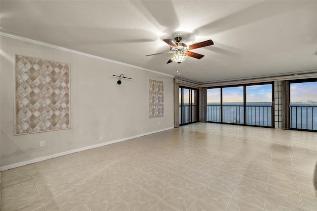 empty room with ceiling fan, floor to ceiling windows, crown molding, a textured ceiling, and a water view