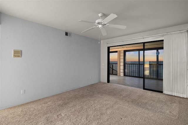 carpeted spare room with ceiling fan