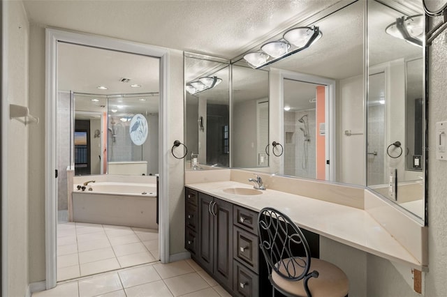 bathroom featuring a textured ceiling, a bathing tub, tile patterned floors, and vanity