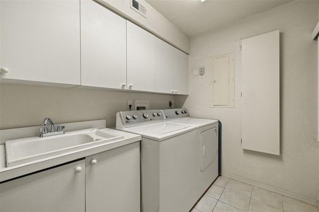 clothes washing area featuring washer and dryer, electric panel, sink, light tile patterned floors, and cabinets