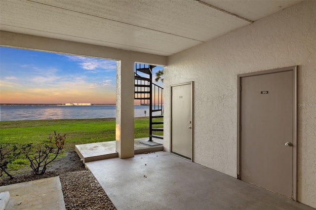 patio terrace at dusk featuring a water view