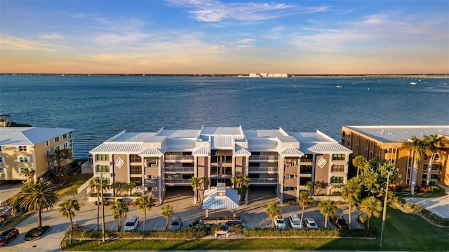 aerial view at dusk featuring a water view