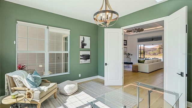 sitting room featuring an inviting chandelier and light wood-type flooring