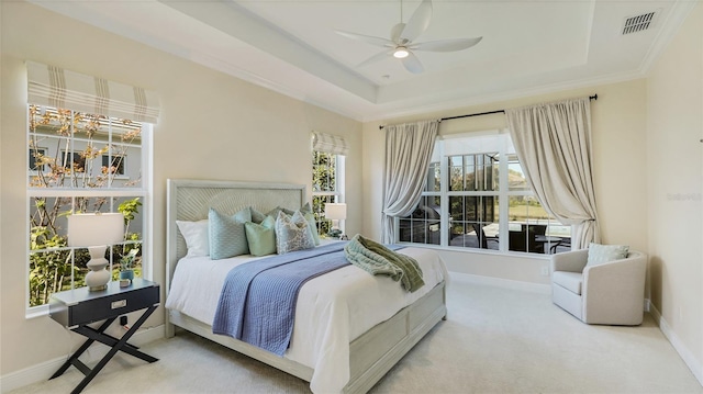 carpeted bedroom featuring ceiling fan and a tray ceiling