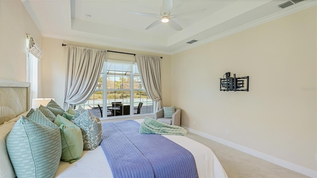 carpeted bedroom with ornamental molding, ceiling fan, and a tray ceiling