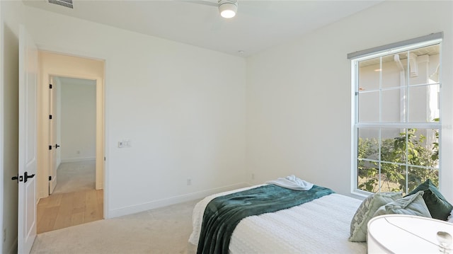 bedroom with ceiling fan and light carpet