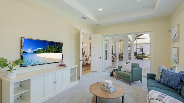 carpeted living room with a tray ceiling