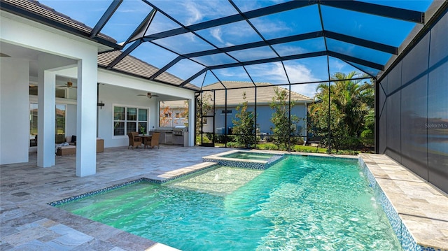 view of swimming pool featuring ceiling fan, a patio, glass enclosure, pool water feature, and an in ground hot tub