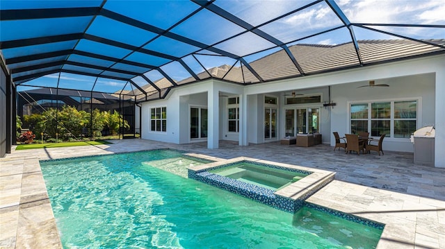 view of pool featuring an in ground hot tub, a patio, ceiling fan, and glass enclosure