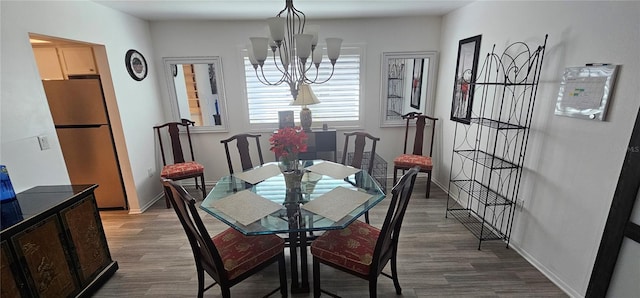 dining space featuring hardwood / wood-style floors and a notable chandelier