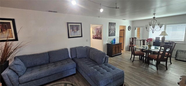 living room with hardwood / wood-style floors and a notable chandelier