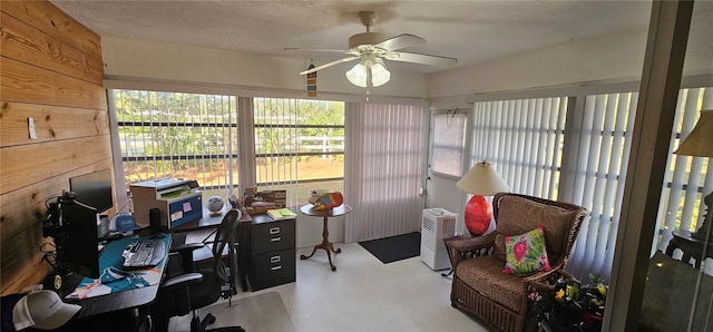 office space with ceiling fan and wooden walls