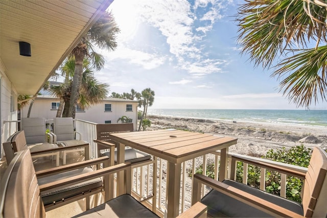 wooden terrace with a view of the beach and a water view