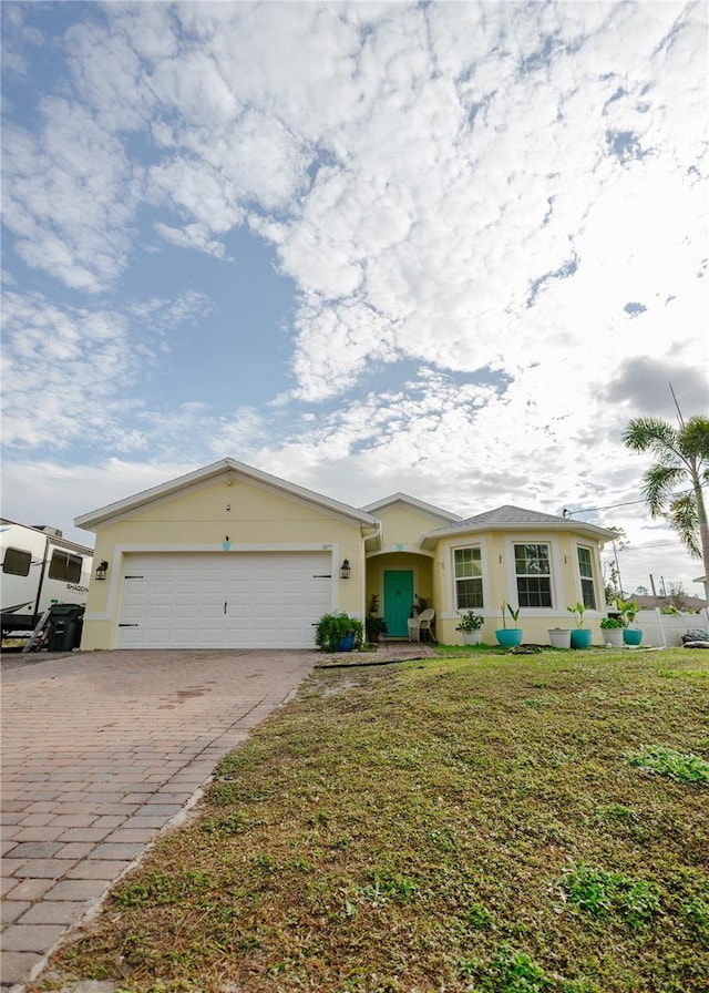 single story home with a garage and a front lawn