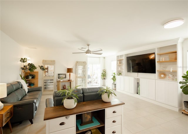 living room with built in shelves, ceiling fan, and light tile patterned flooring